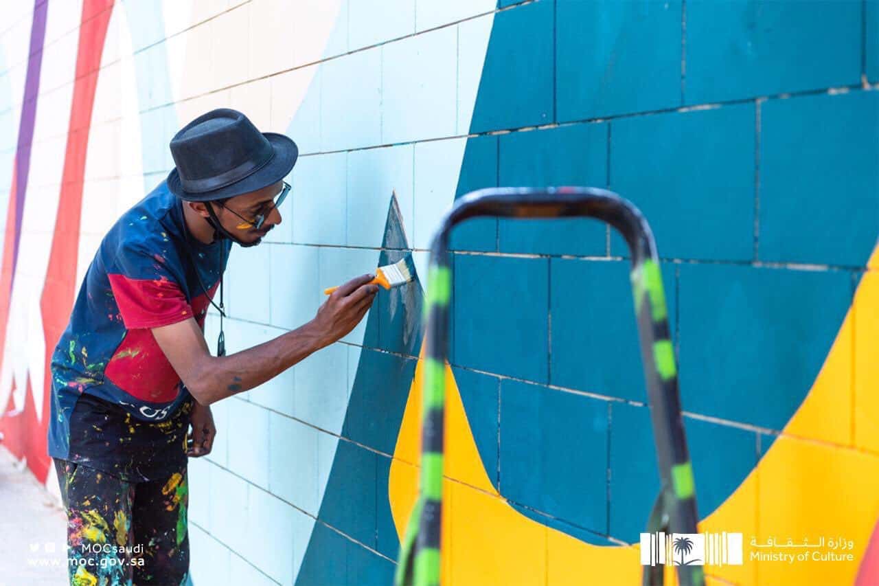 صور| لوحة جدارية تتزين بجمال الخط العربي في حي السفارات