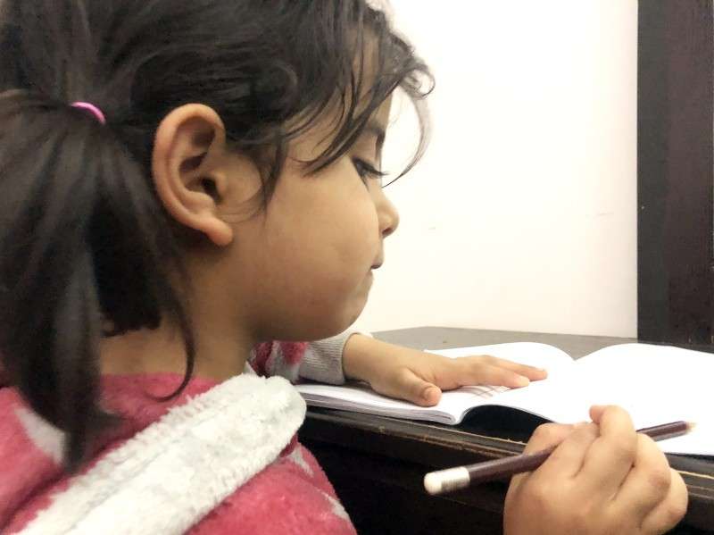طالبة تراجع دروسها من المنزل